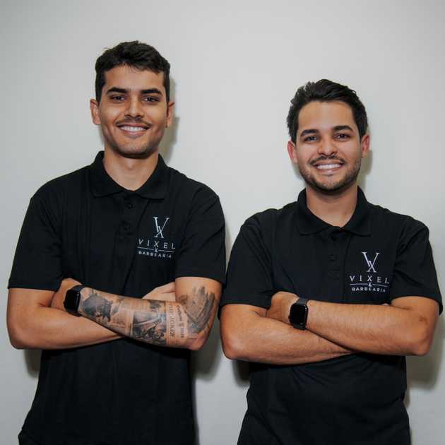 Vitor e Axel, fundadores da Vixel Barbearia, sorrindo e com braços cruzados.